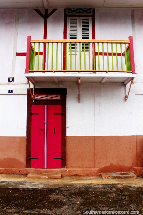 Um balcão rosa e verde e uma porta rosa abaixo em Cayenne, Guiana Francesa. (480x720px). As 3 Guianas, América do Sul.