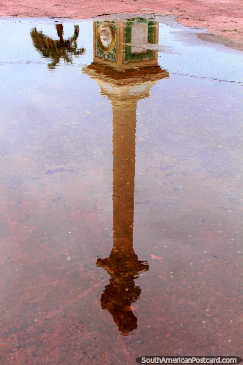 A reflection in a puddle of the tall monument in central Cayenne in French Guiana. (480x720px). The 3 Guianas, South America.