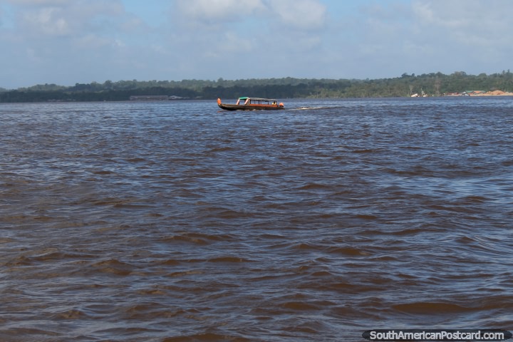 A river boat crosses the Maroni River from Albina to Saint Laurent du Maroni, Suriname. (720x480px). The 3 Guianas, South America.