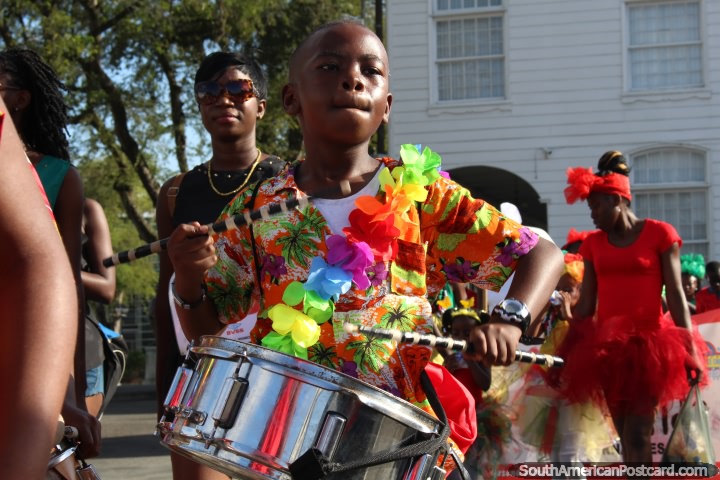 Baterista joven en una camisa y flor collar colorido en el desfile Avondvierdaagse en Paramaribo, Surinam. (720x480px). Las 3 Guayanas, Sudamerica.