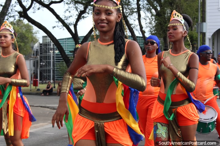 Uma bonita mulher vestiu-se em cores douradas e nacionais na pompa de Avondvierdaagse em Paramaribo, Suriname. (720x480px). As 3 Guianas, América do Sul.