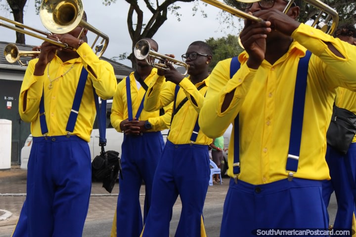 The New Experience Brassband soplar trompetas, vestida de amarillo y azul, el desfile Avondvierdaagse en Paramaribo, Surinam. (720x480px). Las 3 Guayanas, Sudamerica.