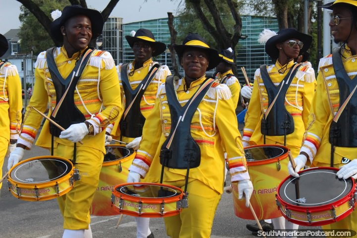 Band dressed in yellow play drums and smile at the Avondvierdaagse parade in Paramaribo, Suriname. (720x480px). The 3 Guianas, South America.