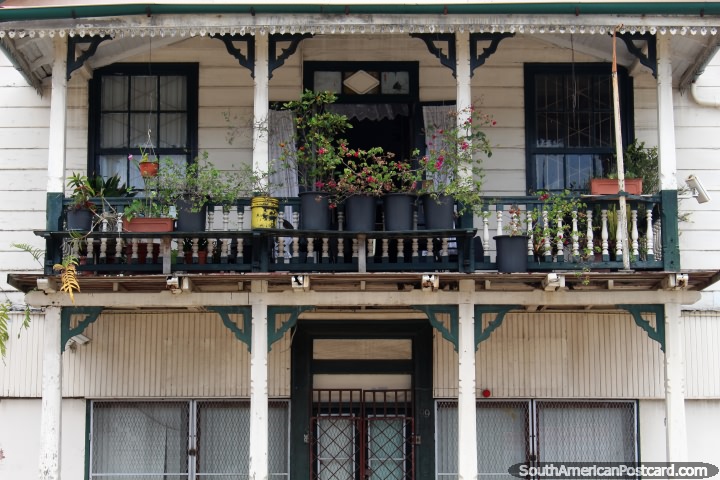 A wooden house with flowerpots on the balcony in Paramaribo, Suriname. (720x480px). The 3 Guianas, South America.