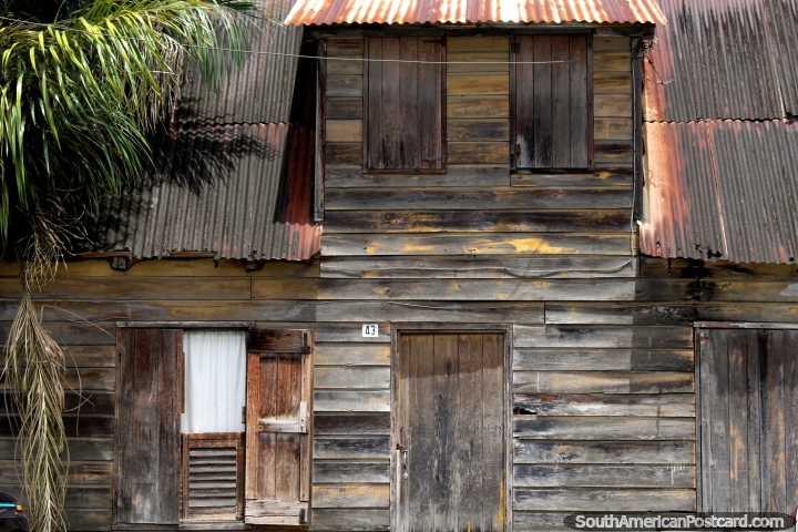 Velha casa de madeira desbotada com portas de madeira e folhas de janela em Paramaribo, Suriname. (720x480px). As 3 Guianas, Amrica do Sul.