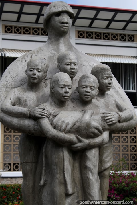 Uma figura mantém 5 crianças, monumento em Paramaribo, Suriname. (480x720px). As 3 Guianas, América do Sul.
