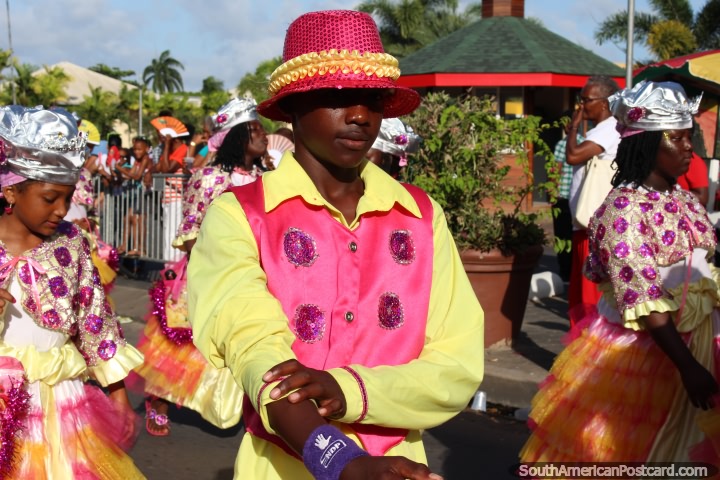 O jovem vestiu-se em um equipamento rosa e amarelo e chapéu na pompa de Avondvierdaagse em Paramaribo, Suriname. (720x480px). As 3 Guianas, América do Sul.
