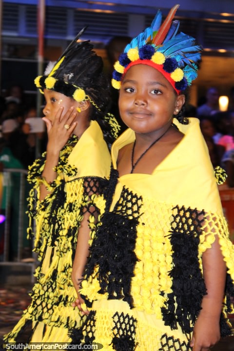 La niña se vistió en amarillo y negro con plumas azules en la cabeza, desfile Avondvierdaagse, Paramaribo, Surinam. (480x720px). Las 3 Guayanas, Sudamerica.