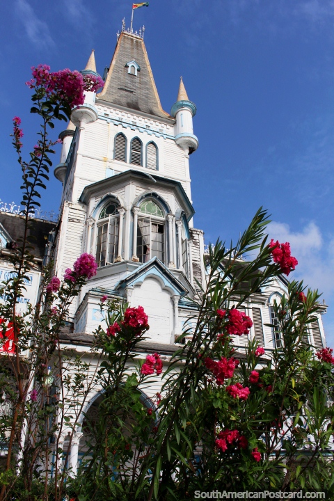 A torre de Paço do concelho com flores rosa no primeiro plano em Georgetown, Guiana. (480x720px). As 3 Guianas, América do Sul.