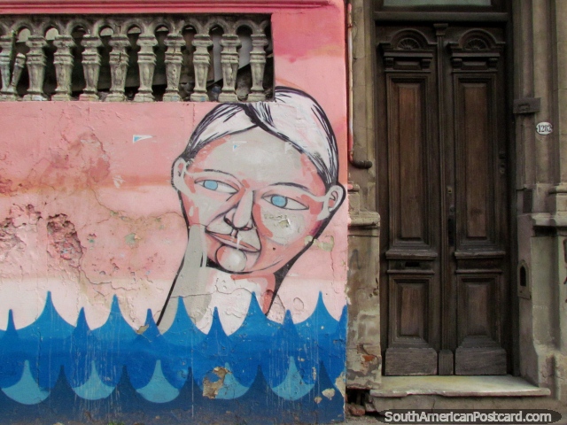 Pintura mural de la pared del Sr. Bottlehead, rosada y azul y una vieja puerta de madera, Buenos Aires. (640x480px). Argentina, Sudamerica.
