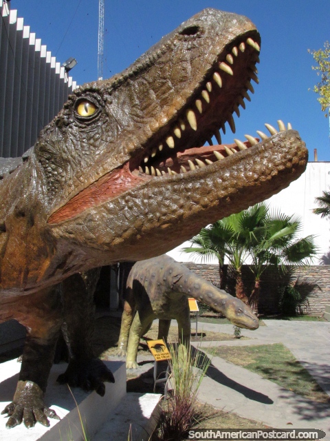 Um par de modelos de dinossauro do lado de fora do edifcio de Cultura e Ministrio do turismo em San Juan. (480x640px). Argentina, Amrica do Sul.
