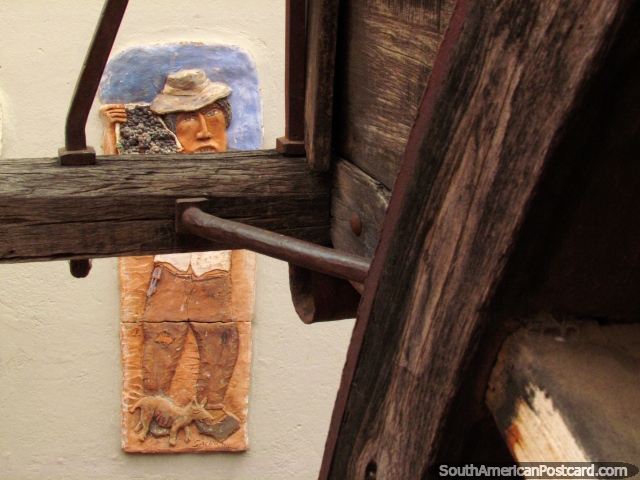 Una obra de arte detrs del carro de madera en el museo de Cafayate, el trabajador lleva uvas. (640x480px). Argentina, Sudamerica.