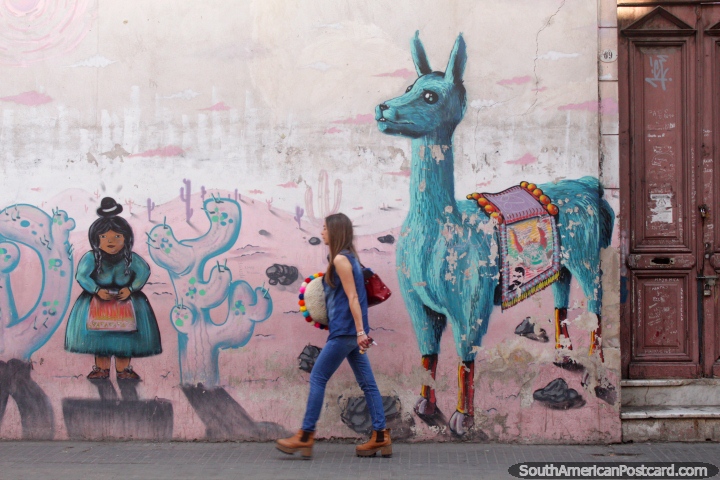 Mural of a girl and a llama in Salta, woman with colorful cushion walks past. (720x480px). Argentina, South America.