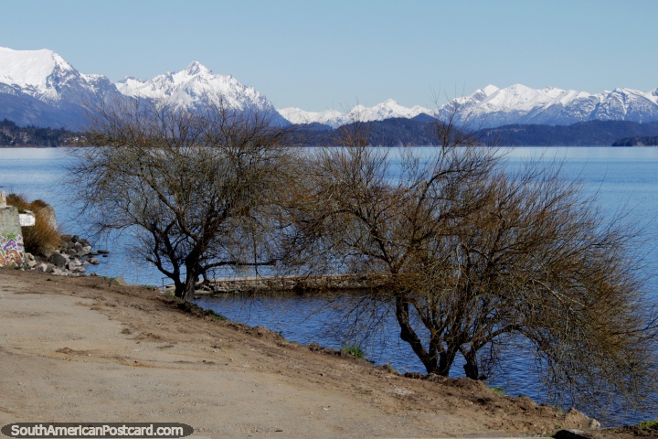 A linha costeira de um lago, árvores e montanhas em Bariloche. (720x480px). Argentina, América do Sul.