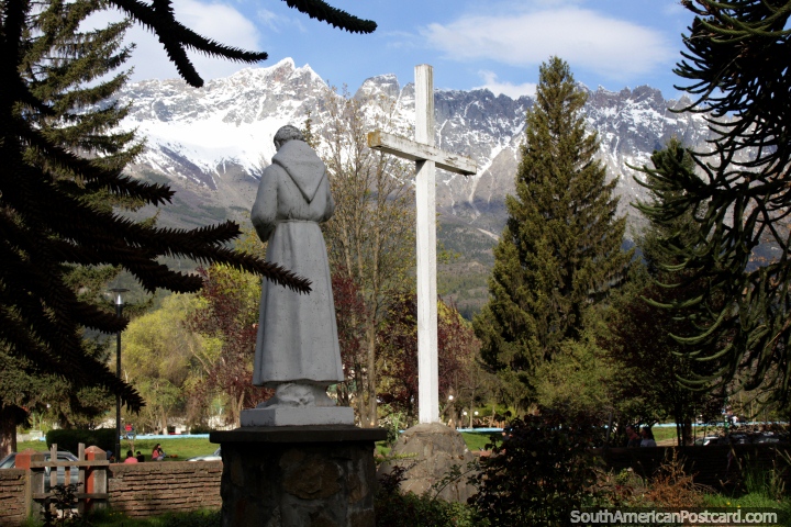 Dos jardins da igreja com esttua e cruz que olha em direo ao parque e montanhas nevosas em El Bolson. (720x480px). Argentina, Amrica do Sul.