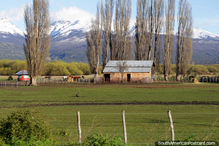 Celeiro em uma fazenda, grupo de cavalos, tanque de água e uma visão bonita do caminho fora de Trevelin a borda. (720x480px). Argentina, América do Sul.