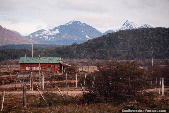 Casa na Terra do Fogo com montanhas distantes em Tolhuin, terreno spero. (720x480px). Argentina, Amrica do Sul.