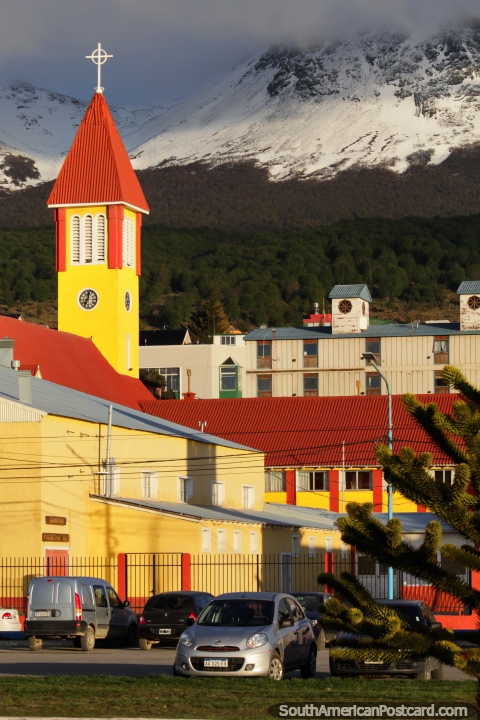 Torre de igreja amarelo-viva e montanhas cobertas de neve em Ushuaia central. (480x720px). Argentina, Amrica do Sul.