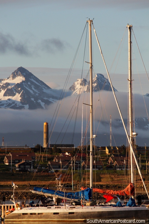 Masts of yachts glow in the morning sun and beautiful snow-capped mountains in Ushuaia. (480x720px). Argentina, South America.