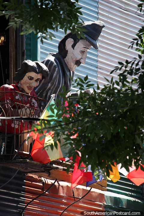 Dos figuras gigantes miran hacia la calle desde un balcón en La Boca en Buenos Aires, ¿quiénes son? (480x720px). Argentina, Sudamerica.