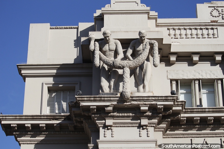 2 men wrestle with a snake or large caterpillar, amazing building facade in Bahia Blanca. (720x480px). Argentina, South America.