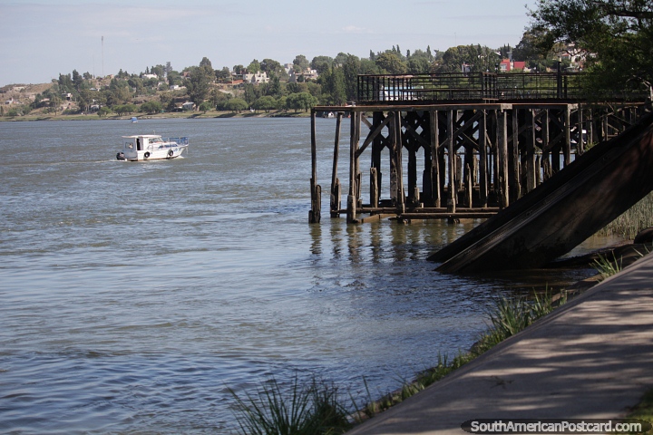 Boat on the Negro River and the old wooden dock in Patagones. (720x480px). Argentina, South America.
