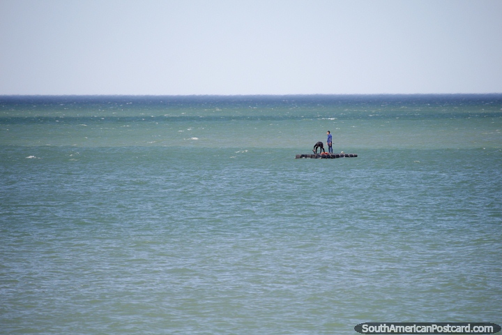 Pair of people on a raft out in the ocean in Comodoro Rivadavia. (720x480px). Argentina, South America.