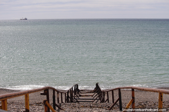 Boat ramp down to the ocean, a distant ship in Caleta Olivia. (720x480px). Argentina, South America.