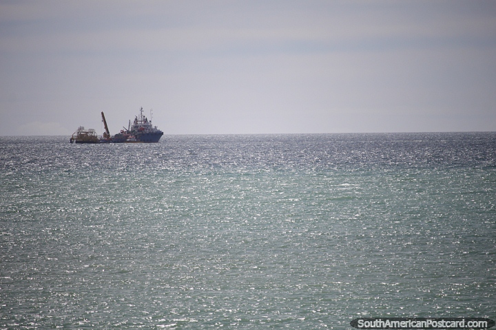 Ship working with cranes in the ocean in front of Caleta Olivia. (720x480px). Argentina, South America.