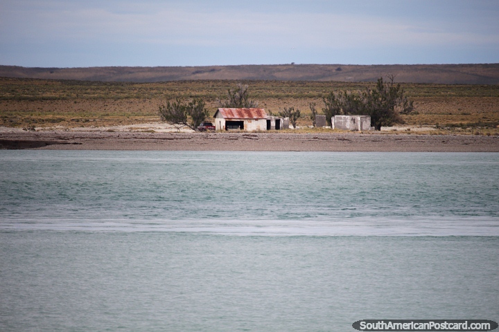 Grasslands across the waters and an old shed in Puerto Deseado. (720x480px). Argentina, South America.