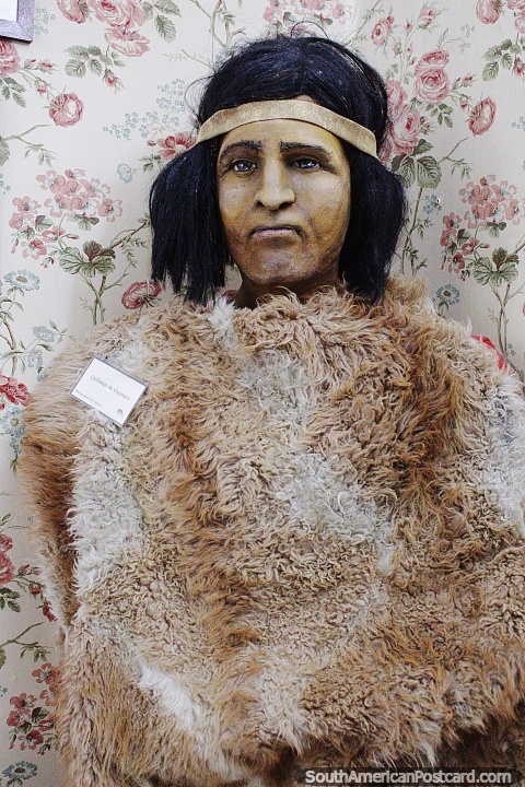 Indigenous man dressed in Guanaco fur, a model at the Pioneers museum in Rio Gallegos. (480x720px). Argentina, South America.