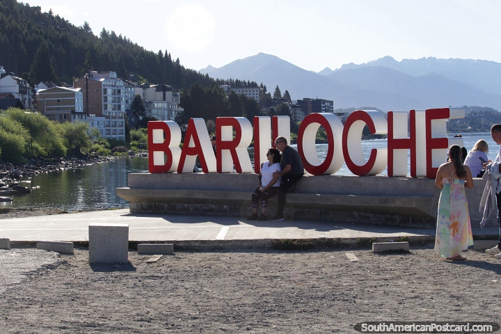 Grandes letras vermelhas soletram Bariloche, um lugar para uma foto à beira do lago. (720x480px). Argentina, América do Sul.