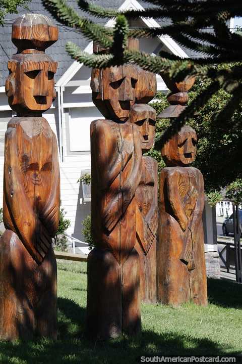 Grupo de 4 esculturas de madera en el césped con vista al lago en Bariloche. (480x720px). Argentina, Sudamerica.