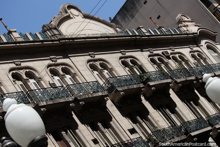 Many iron balconies with wooden doorways and arches of this building in Rosario. (720x480px). Argentina, South America.
