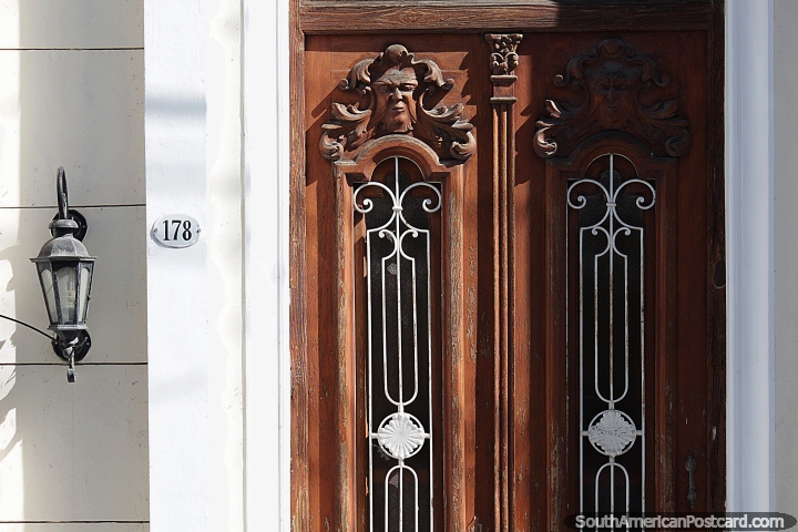 Decorative faces sculpted on a wooden door in Jujuy, antique. (720x480px). Argentina, South America.
