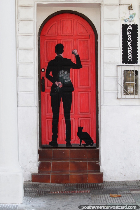 Un hombre con flores llama a la puerta, un portal llamativo ilumina la calle de Santa Cruz. (480x720px). Bolivia, Sudamerica.
