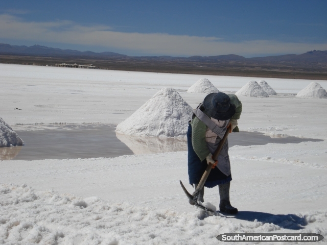 Lady with pick making piles of salt in the Salar de Uyuni. (640x480px). Bolivia, South America.