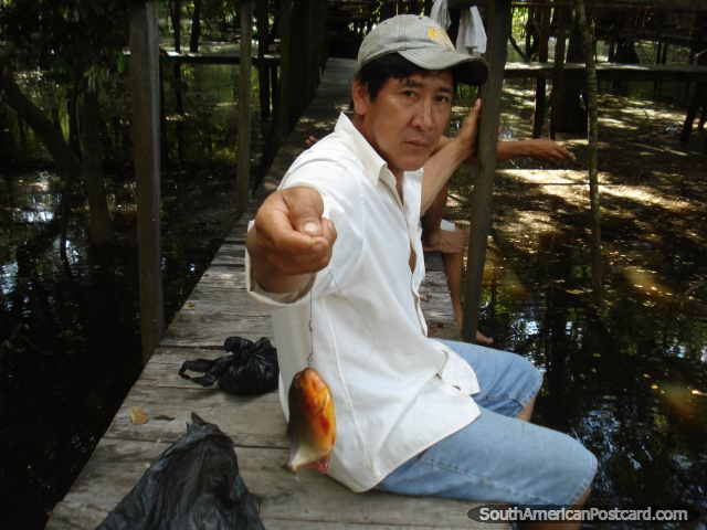 Local man catches a piranha in Rurrenabaque. (640x480px). Bolivia, South America.