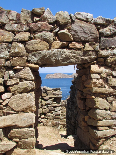 Rock doorway of Inca ruins looks out to small island at Lake Titicaca. (480x640px). Bolivia, South America.