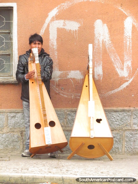 Homem com 2 grandes instrumentos de corda em Potosi. (480x640px). Bolívia, América do Sul.