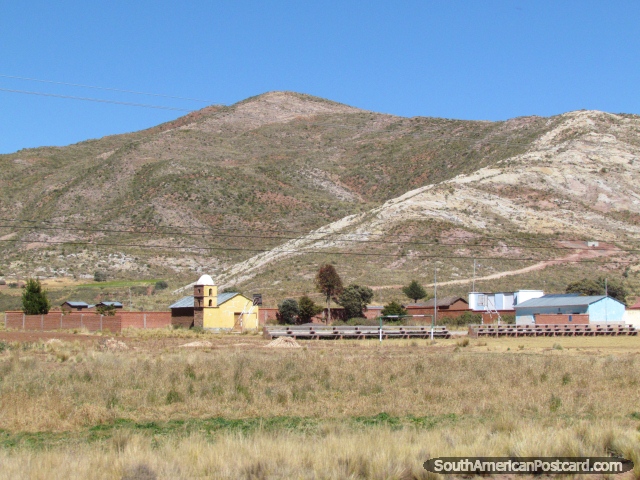 La pequea iglesia amarilla al lado de una pista de baloncesto y ftbol lanza entre Guaqui y Desaguadero. (640x480px). Bolivia, Sudamerica.