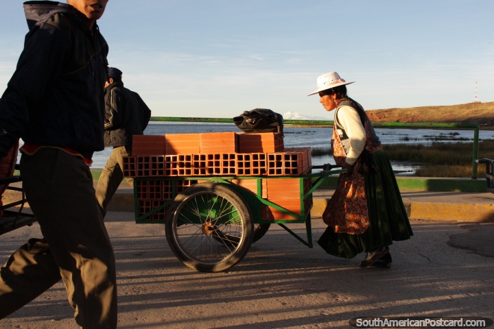 Outra mulher que empurra uma carreta cheia de tijolos atravs da ponte em Desaguadero. (720x480px). Bolvia, Amrica do Sul.