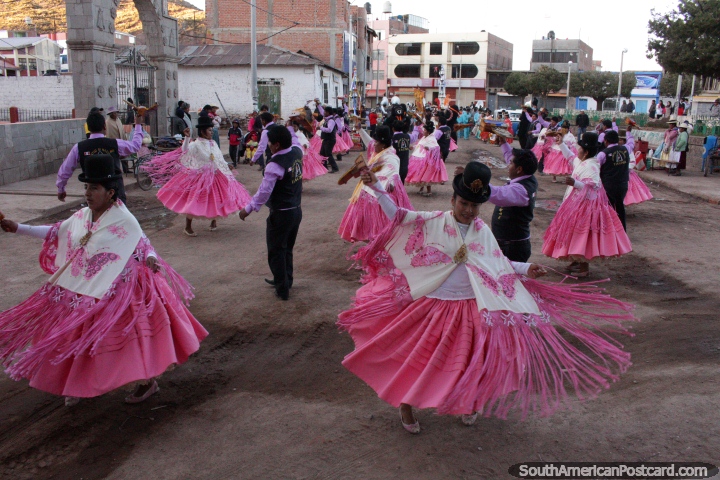 Women in pink and white, men in purple and black, locals dancing in Desaguadero. (720x480px). Bolivia, South America.