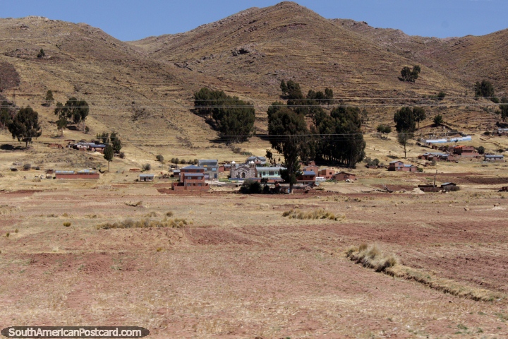 Una comunidad por debajo de las colinas con una iglesia de piedra entre Desaguadero y Tiahuanaco. (720x480px). Bolivia, Sudamerica.