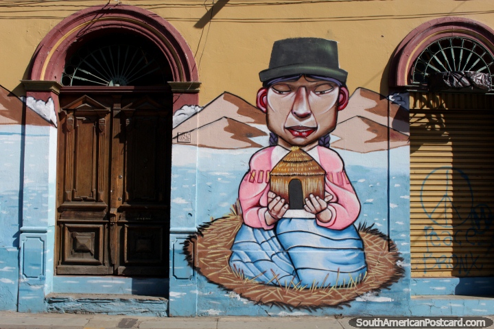 Woman holds a birdhouse, great mural between 2 old doors in Cochabamba. (720x480px). Bolivia, South America.