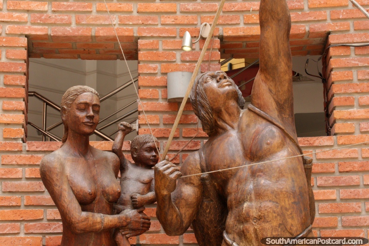 Wooden sculptured family of 3, man shoots a bow and arrow, Santa Cruz. (720x480px). Bolivia, South America.