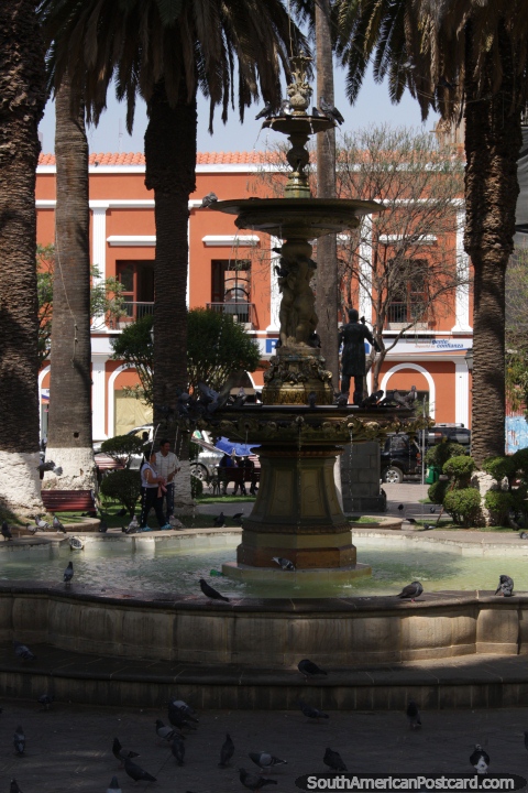 Fountain, pigeons and palm trees at the main plaza in Tarija. (480x720px). Bolivia, South America.