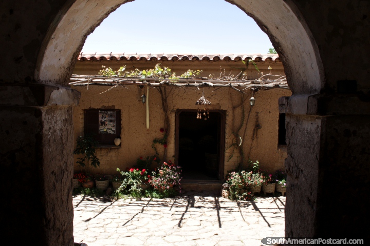 Ver a travs de una puerta de piedra arqueada al patio en La Casa Vieja Viedo cerca de Tarija. (720x480px). Bolivia, Sudamerica.