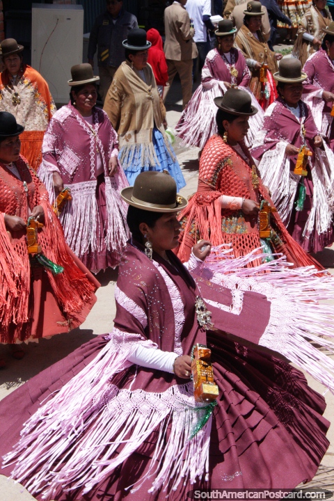 Las mujeres de sombreros de Copacabana con vestidos anchos bailan y actan en la calle para el carnaval. (480x720px). Bolivia, Sudamerica.
