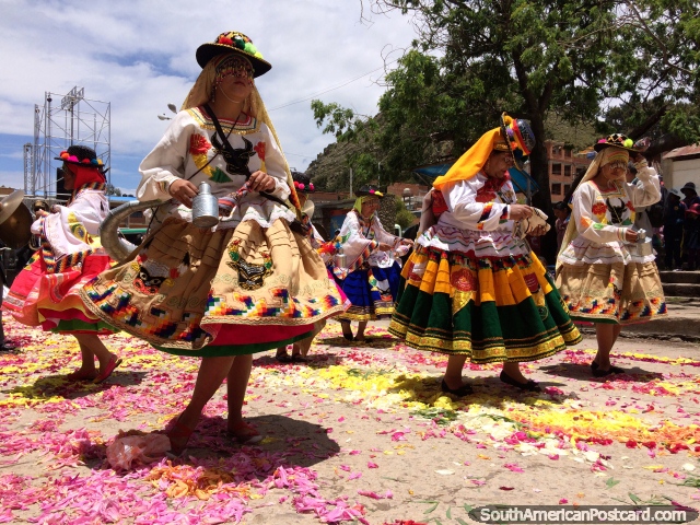 Dancers perform on streets laid with pink and yellow flowers in Copacabana. (640x480px). Bolivia, South America.